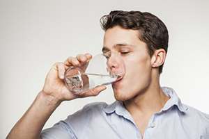 man drinking glass of water