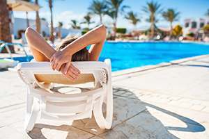 woman sun bathing beside the swimming pool