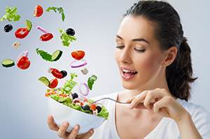 woman holding a bowl of vegetable salad