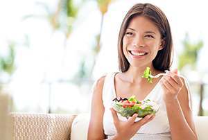 photo of happy woman holding a bowl of fresh salad