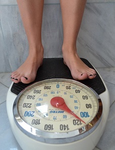 Woman Stepping on Weighing Scale