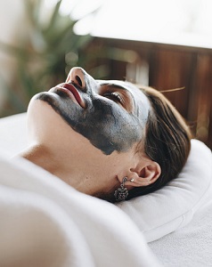 Woman relaxing with a facial mask at the spa