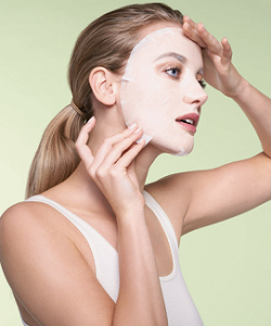 Woman Applying Sheet Mask on Face