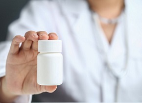 Female doctor holding and showing a medicine bottle